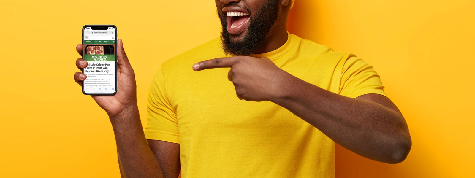 Excited man in yellow shirt points at his phone after participating in a trade promotion