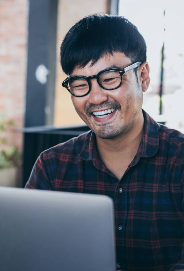 Happy man with glasses using laptop