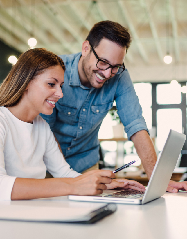Two young business colleagues using a laptop